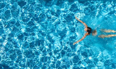 Woman swimming in a crystal clear blue pool