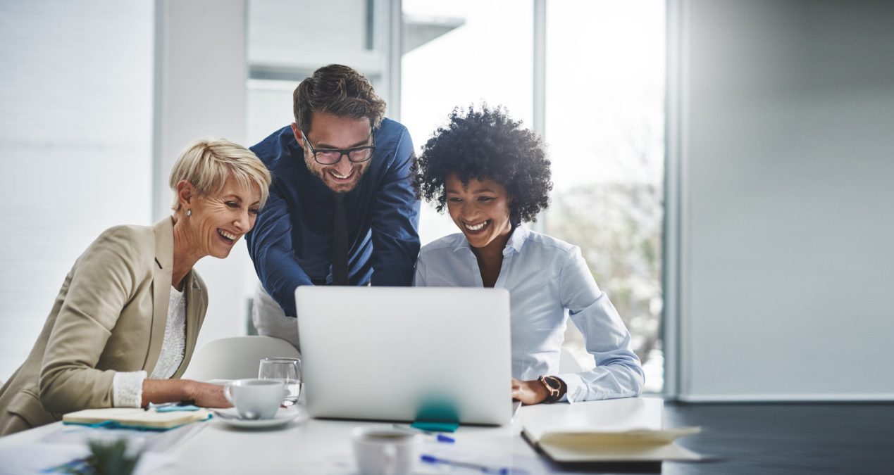 three people working on one computer